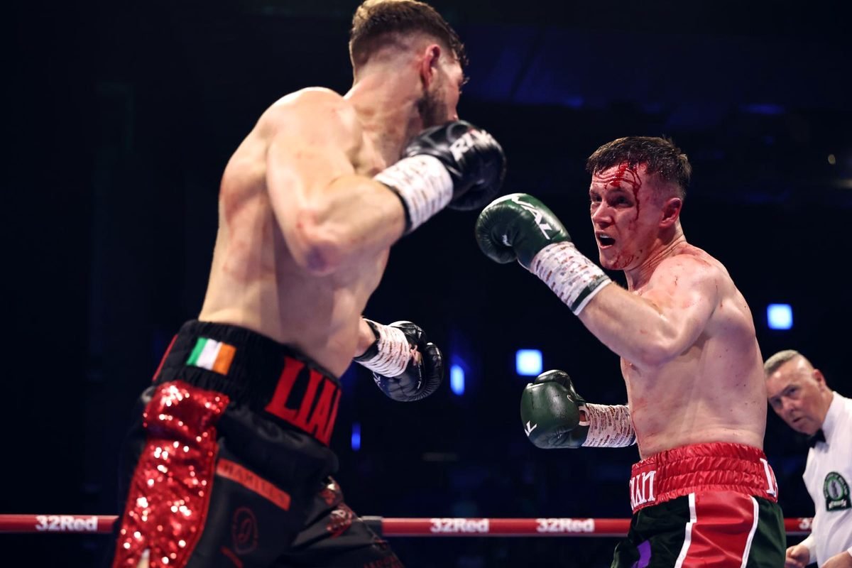 Liam Walsh in black and red shorts facing Eoghan Lavin in a Dublin arena